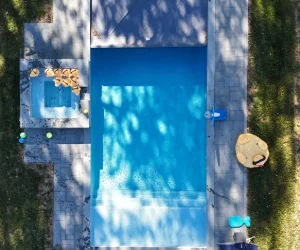 A bird's eye view of a residential pool with masonry surrounding it