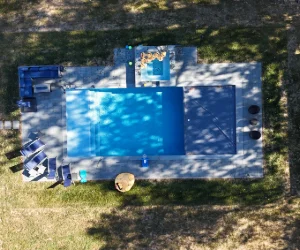 A bird's eye view of a residential pool surrounded by a finished masonry project