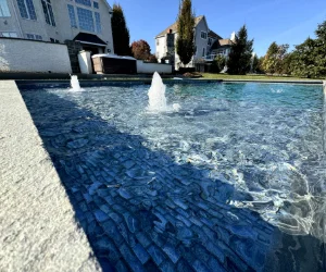 An outdoor pool with a floor done by Piazza Outdoor's masonry services