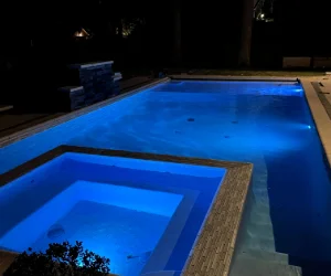 Light gray bricks surrounding a jacuzzi within a swimming pool