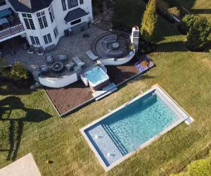 A bird's eye view of a residential backyard with a masonry patio